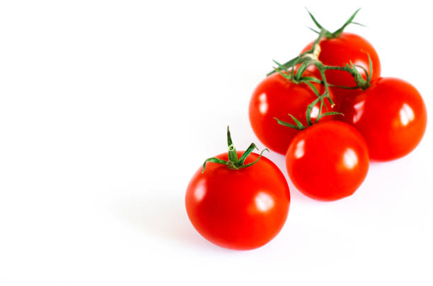 istock Red juicy cherry tomatoes with green tails lying on a white background 1150463248