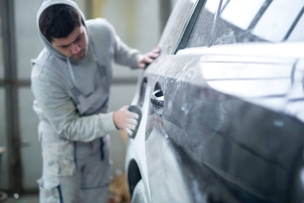 istock Repairman preparing car for painting in workshop. 1150464166