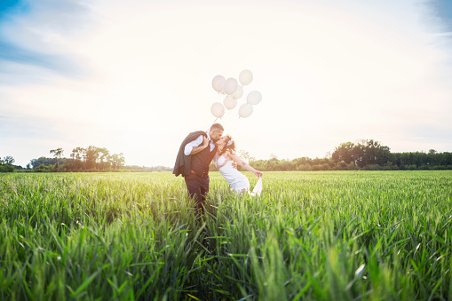 Beautiful couple with balloons at wheat field