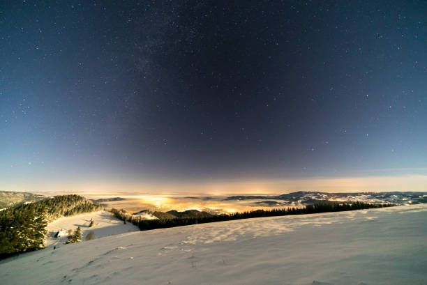 istock Elevated perspective of night sky and snow covered forest 1150465165