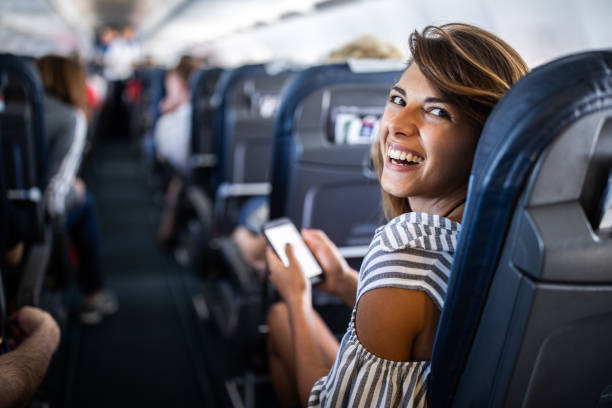istock Happy woman enjoying while using cell phone in a plane. 1150465443