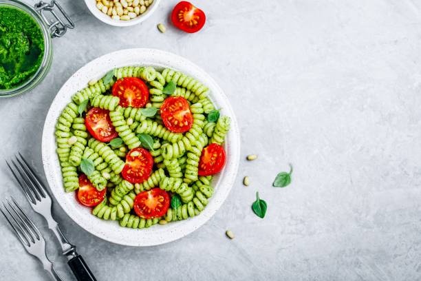 istock Fusilli pasta with basil pesto sauce , tomatoes and pine nuts. 1150467248