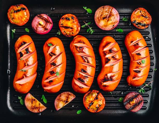 istock Grilled sausages and vegetables in cast iron pan closeup. 1150467603