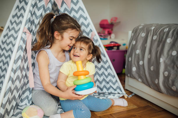 istock Girls hugging and playing at home 1150467610