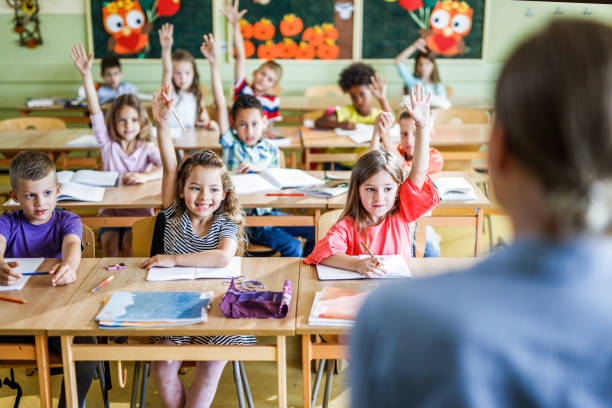 istock Happy school kids know the answer to teacher's question at elementary school. 1150469878