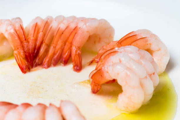 Tasty shrimps cooking on a hot pan with olive oil, shaped in round formation