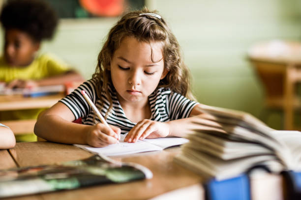istock Schoolgirl writing her lecture in notebooks in the classroom. 1150470638