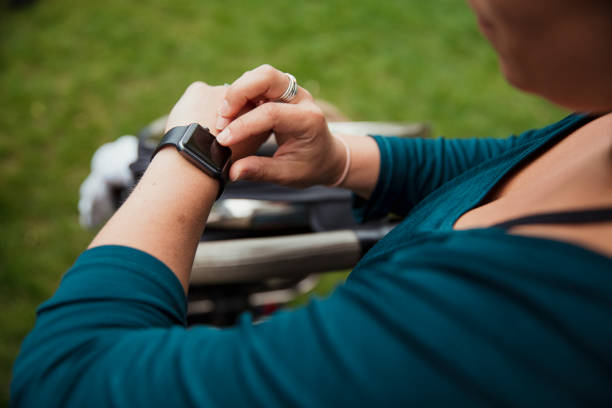 Tracking my Personal Best A woman is checking her pulse on her wearable technology smartwatch during exercise outdoors. pedometer stock pictures, royalty-free photos & images