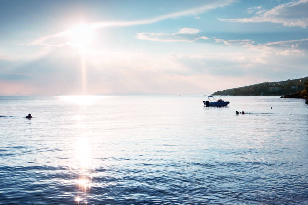 Sunbeams breaking through clouds and glittering on sea surface