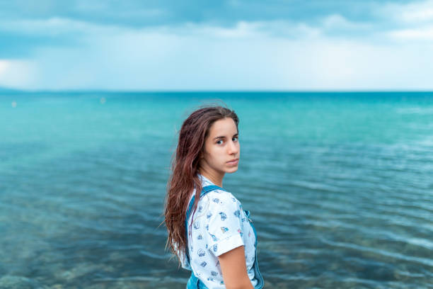 adolescente in camicia e tute jean in mare - only teenage girls teenager adolescence sea foto e immagini stock