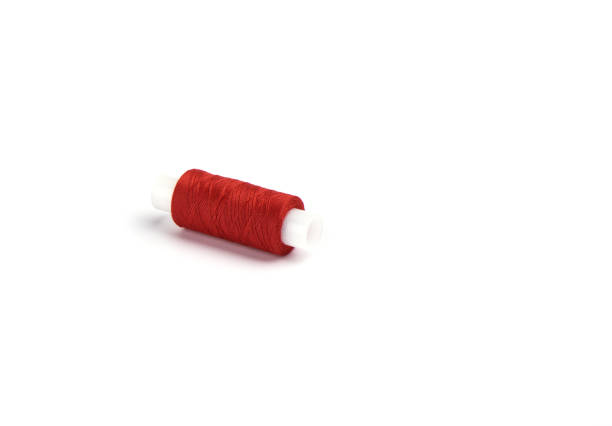 istock Cotton red threads on the plastic sleeve for the sewing machine. 1150471998