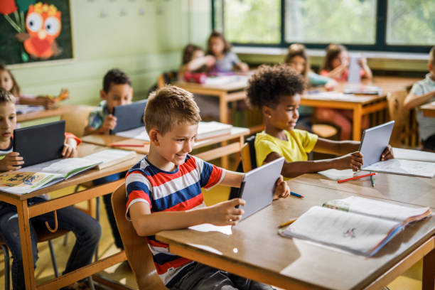 istock Happy school kids e-learning over digital tablet in the classroom. 1150473757