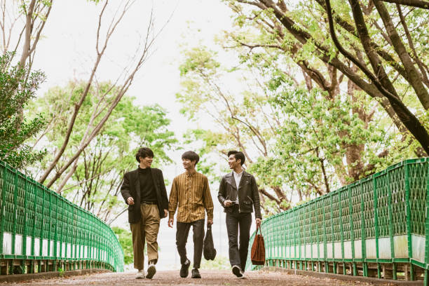 istock Three Japanese men in their 20s walking to work on footbridge 1150475314