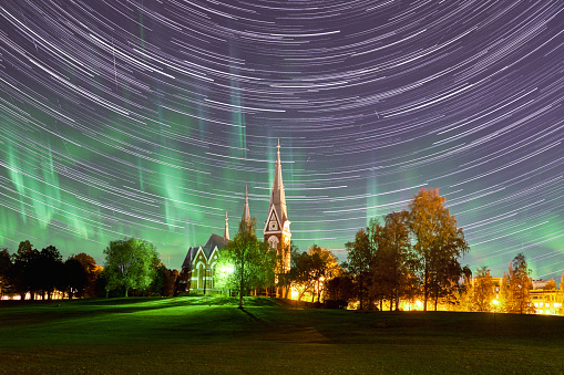 Joensuu Church on the background of stars trails and aurora