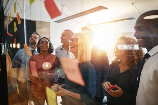 istock Smiling businesspeople brainstorming together with sticky notes in an office 1150482842
