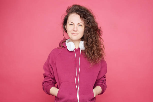 istock Pretty lady looking at camera on pink studio wall 1150484103