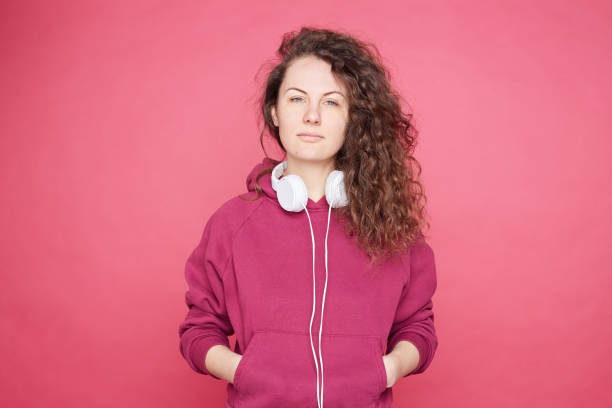 istock Pretty lady looking at camera on pink studio wall 1150484177