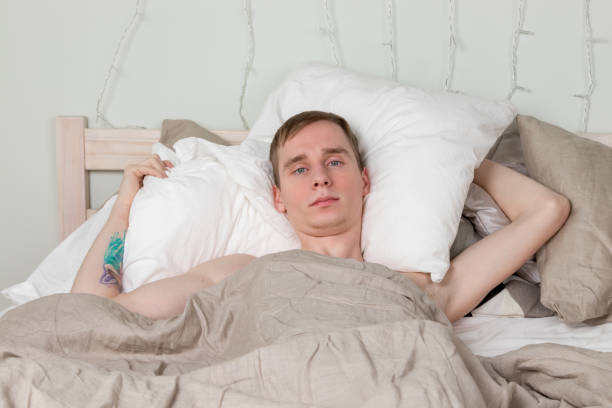 istock Handsome young adult man sleeping in bed. Guy is resting 1150484357