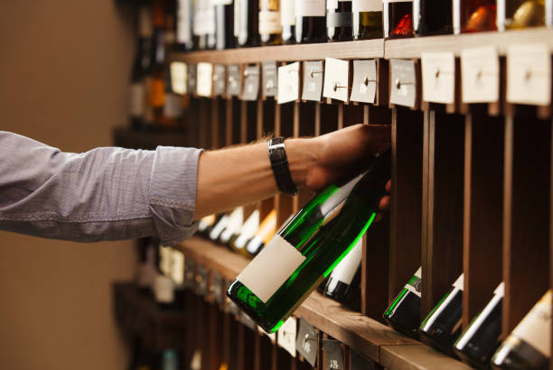 Expert in winemaking choose elite white wine in cellar.