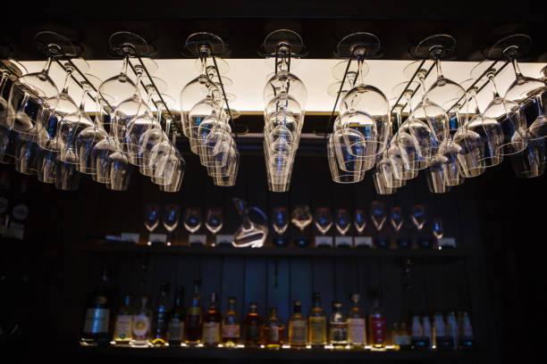 Empty wine glasses hanging upsidedown in bar interior.