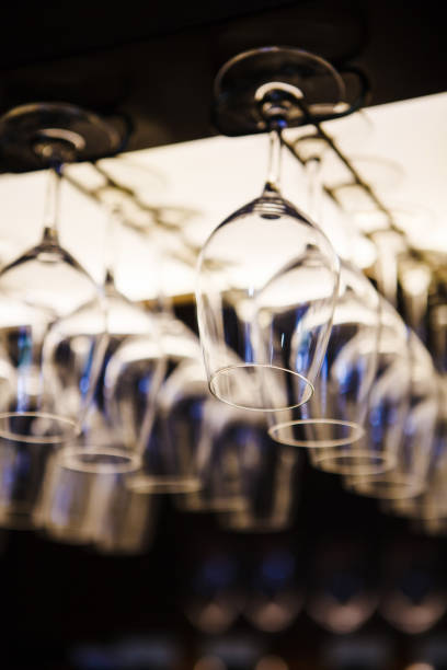 istock Empty wine glasses hanging upsidedown in bar interior. 1150485986