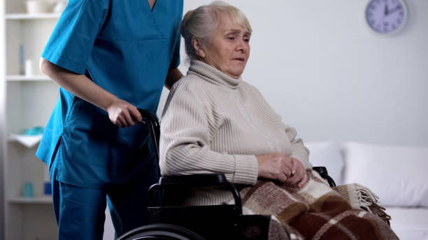 trabajador médico que se preocupa por molestar a la señora mayor en silla de ruedas, rehabilitación - women middle aging process covering fotografías e imágenes de stock