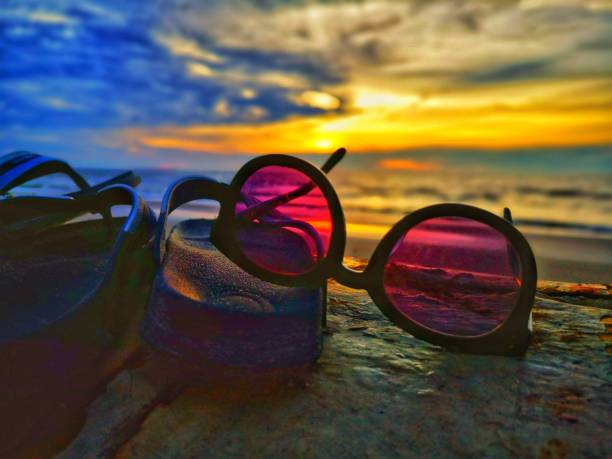 istock Beautiful sunset view with flip-flop and sunglasses on beach background. 1150489363