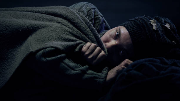 istock Freezing crying homeless woman looking at camera, taking cover, social problems 1150489610