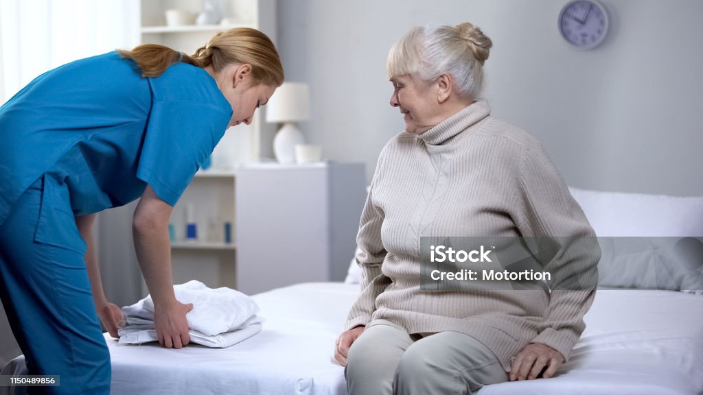 damnificados Sembrar Pulido Enfermera Preparando Ropa De Cama Limpia Para La Mujer Anciana Paciente En  El Centro Médico Foto de stock y más banco de imágenes de Limpiar - iStock