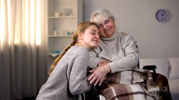 nieta abrazando abuela discapacitada, amabilidad familiar, voluntariado - women middle aging process covering fotografías e imágenes de stock