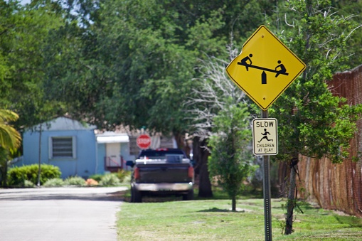 yellow diamond sign with see-saw and SLOW Children at Play sign