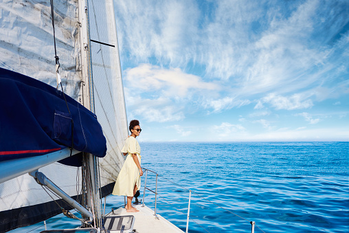Shot of a young woman enjoying a relaxing day on a yacht
