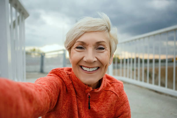 Senior woman making a selfie before jogging Senior woman a selfie photo messaging stock pictures, royalty-free photos & images