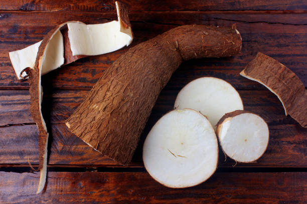 istock fresh cassava and peels and slices on rustic wooden table. Top view 1150495966