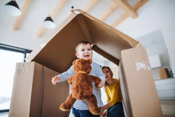 Photo of A portrait of young family with a toddler girl, moving in new home concept.