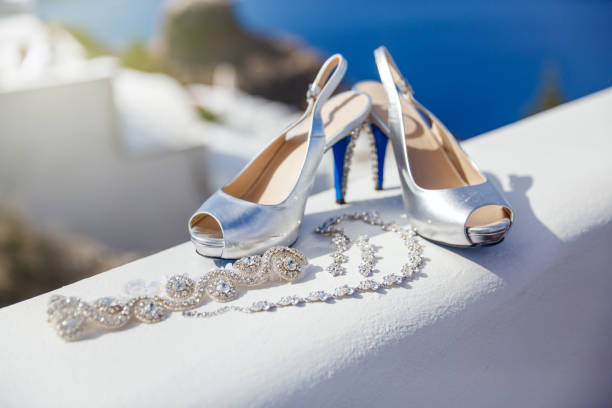 White wedding shoes and jewelry on the background of the sea and the island of Santorini