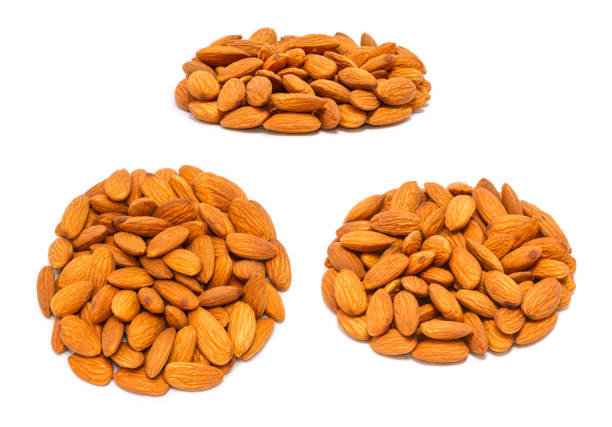 Set of handfuls of nuts from different angles - almond seeds (Prunus dulcis) without shell, close up, isolated on white background