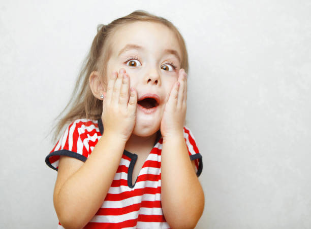 istock Surprised little girl with open mouth and hands on cheeks 1150499982