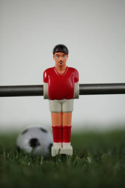 istock Red foosball plastic players. Soccer ball 1150500427
