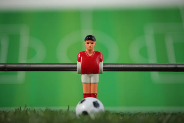 istock Red foosball plastic players. Soccer ball 1150500433