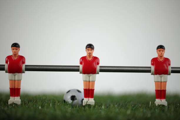 istock Red foosball plastic players. Soccer ball 1150500444