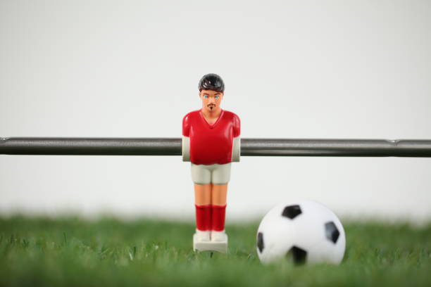 istock Red foosball plastic players. Soccer ball 1150500450