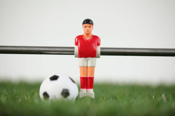 istock Red foosball plastic players. Soccer ball 1150500452