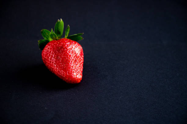 istock Closeup of strawberry fruit on a dark background. 1150501705