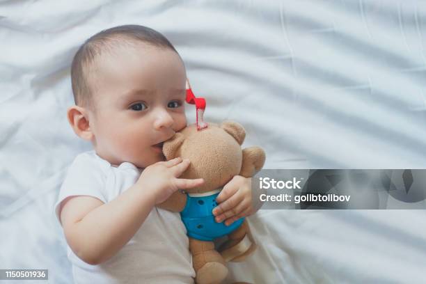 68 Month Old Baby Boy Lying Playfully In Bed Stock Photo - Download Image Now - 0-11 Months, 6-11 Months, Arm