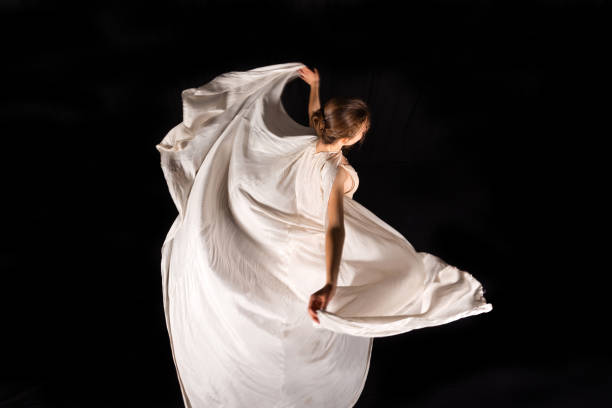istock Young ballerina is dancing on black background 1150501955