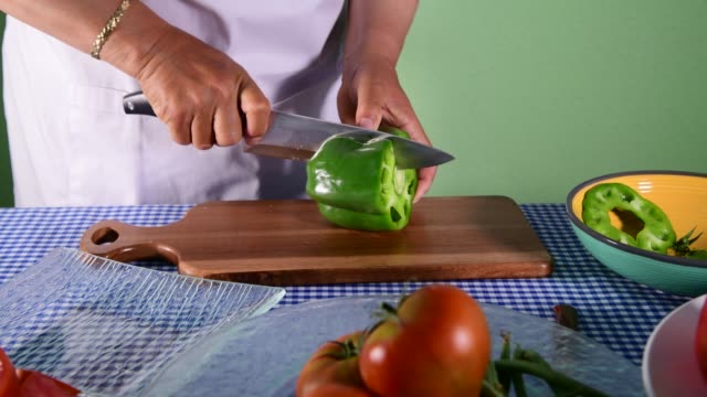 a woman cutting green pepper