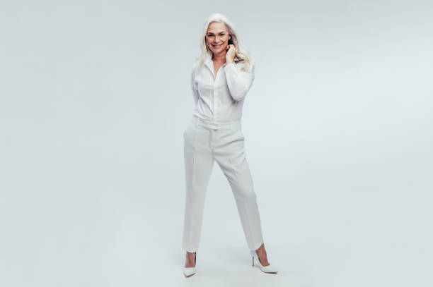 Stay true to your own style Full length portrait of beautiful senior woman standing over white background. Stylish mature woman posing in white casuals. middle aged woman fashion stock pictures, royalty-free photos & images