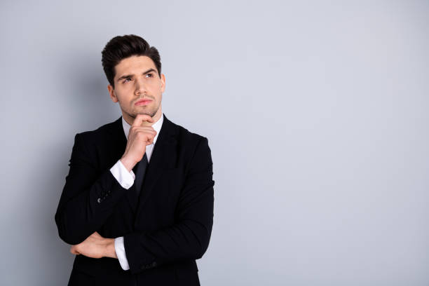 istock Close up photo amazing he him his macho handsome look up empty space arm touch chin deep thinking minded make decision doubtful wear specs shirt suit jacket tie formalwear isolated grey background 1150503309