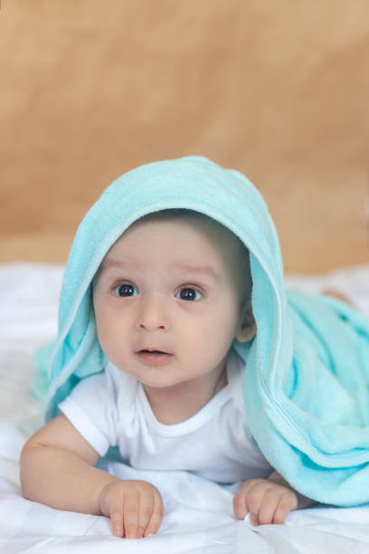 istock 6-8 month old baby boy lying playfully in bed 1150504688